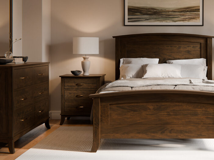 A cozy bedroom featuring a dark wood bed with white bedding, matching nightstand and dresser, and a table lamp. Above the bed hangs a landscape painting.